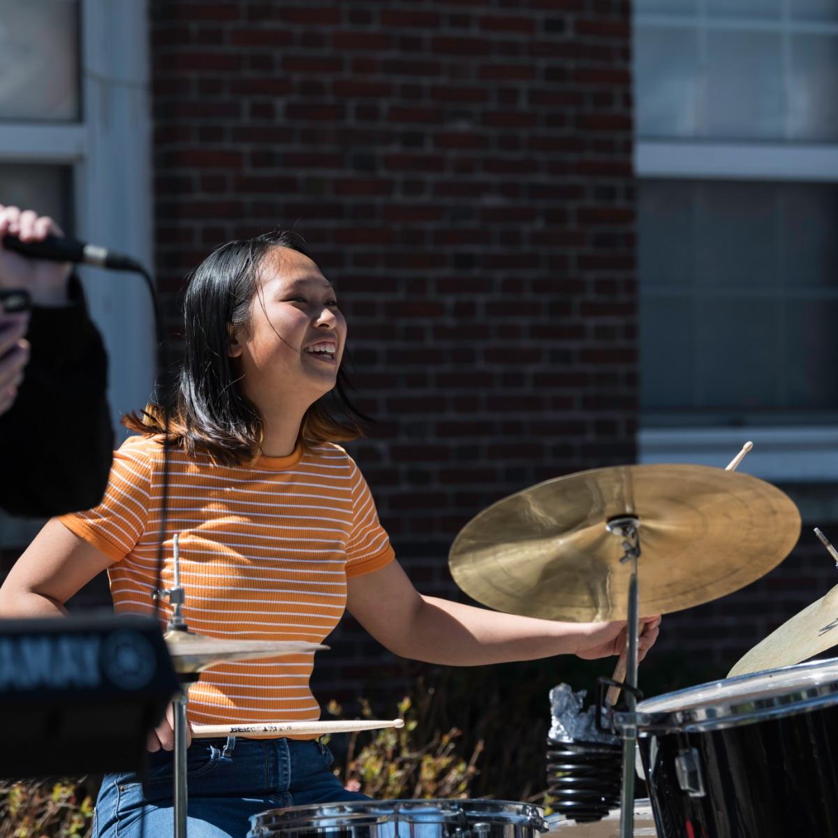 University of Rochester student plays the drums outside